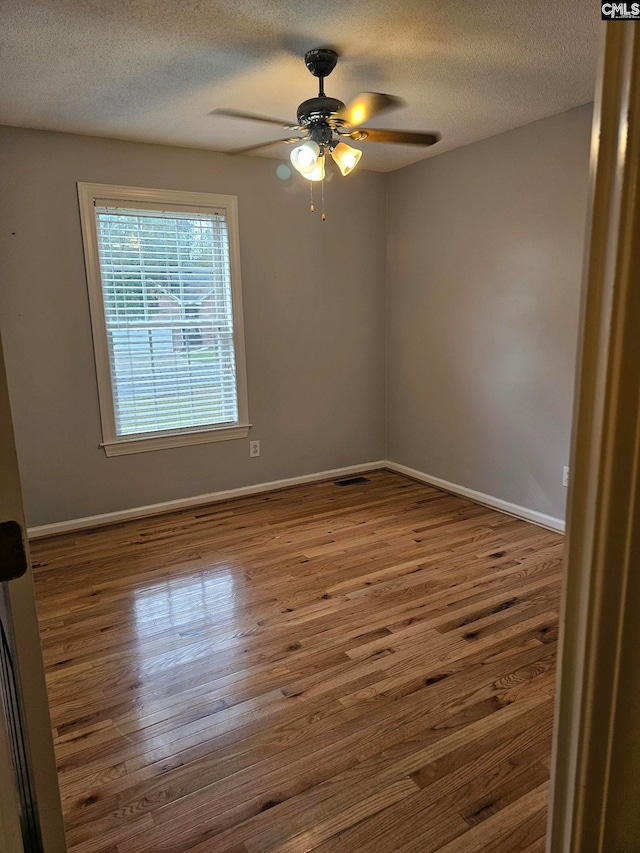 unfurnished room featuring a textured ceiling, hardwood / wood-style flooring, and ceiling fan