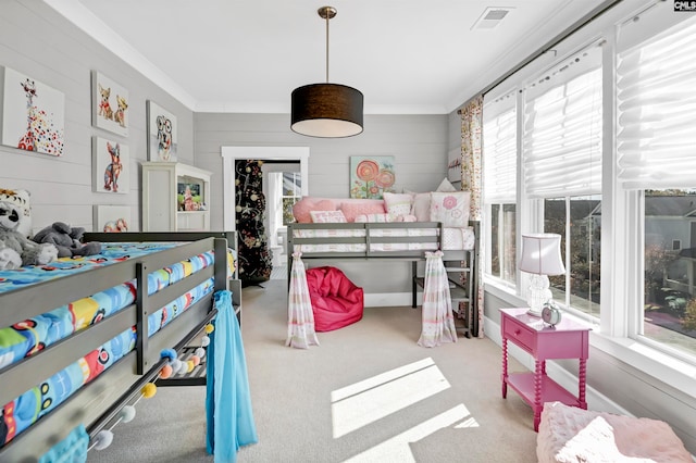 carpeted bedroom with wood walls, crown molding, and multiple windows