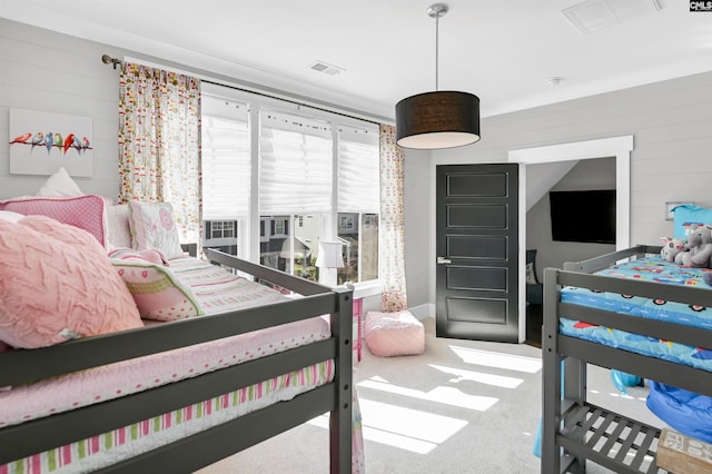 bedroom featuring wooden walls and carpet