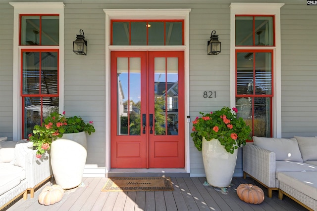 view of exterior entry featuring a porch and french doors