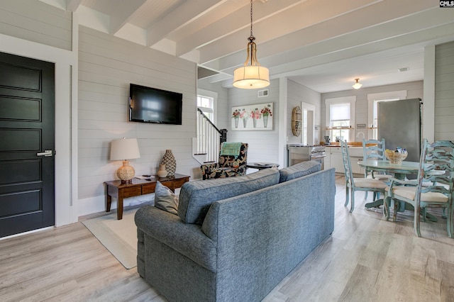 living room with wood walls and light hardwood / wood-style floors