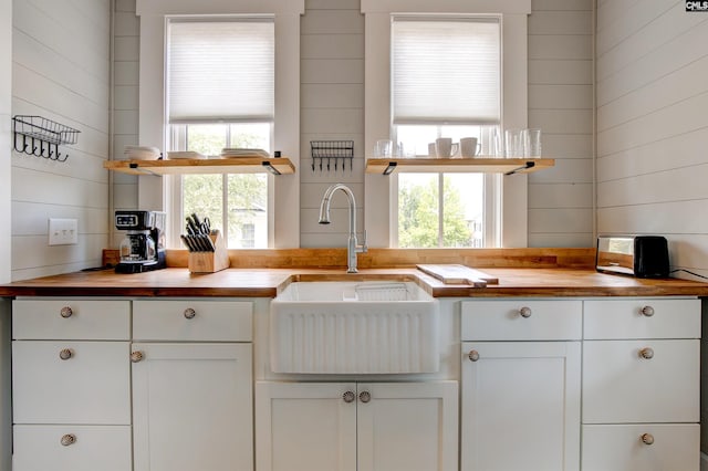 kitchen featuring white cabinetry, a wealth of natural light, sink, and wooden counters