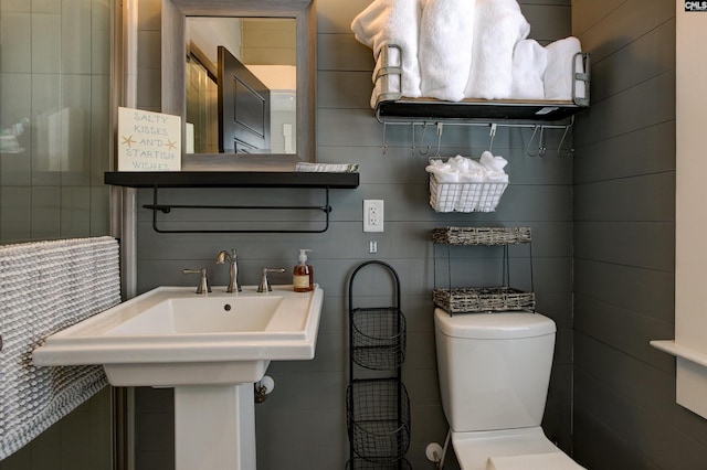 bathroom featuring toilet and tile walls