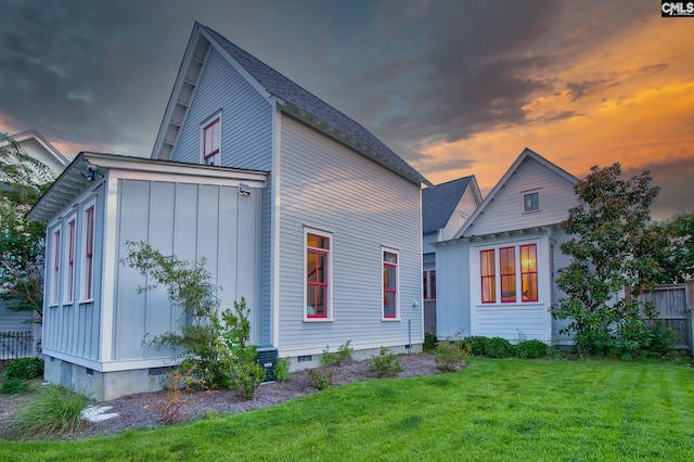 back house at dusk featuring a yard