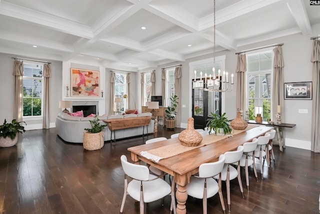 dining space featuring beam ceiling, dark wood-type flooring, coffered ceiling, and an inviting chandelier