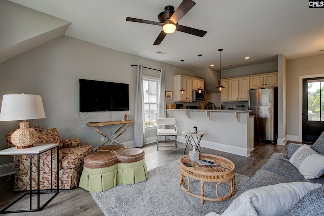 living room featuring ceiling fan, light hardwood / wood-style flooring, and lofted ceiling