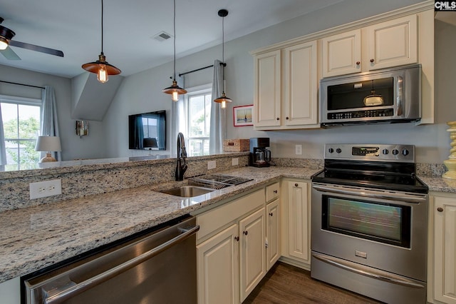 kitchen featuring a wealth of natural light, sink, cream cabinetry, and appliances with stainless steel finishes