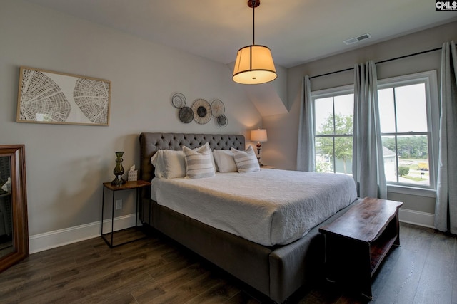 bedroom with multiple windows and dark hardwood / wood-style floors