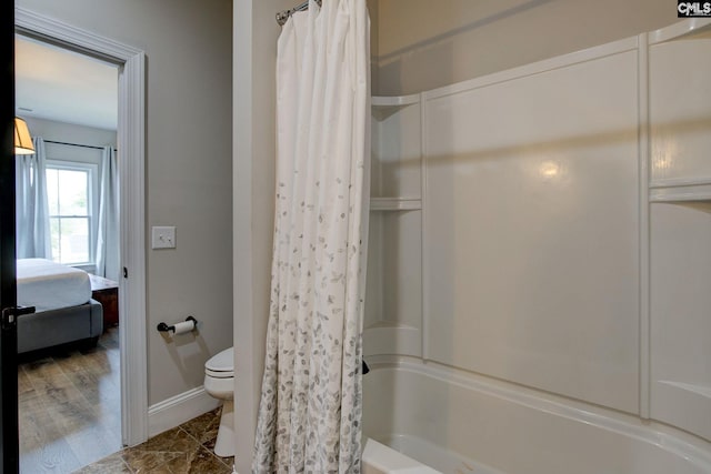 bathroom with hardwood / wood-style floors, shower / tub combo, and toilet