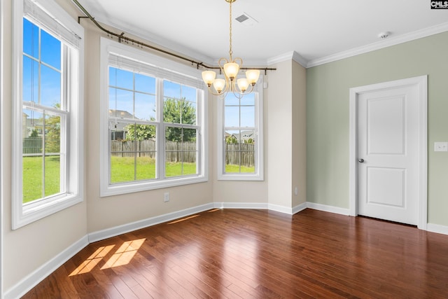 unfurnished dining area featuring a healthy amount of sunlight, crown molding, dark wood-type flooring, and a chandelier