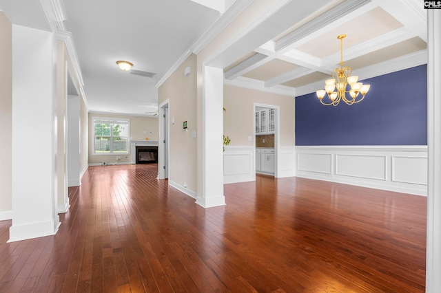 empty room featuring coffered ceiling, an inviting chandelier, ornamental molding, beam ceiling, and dark hardwood / wood-style flooring