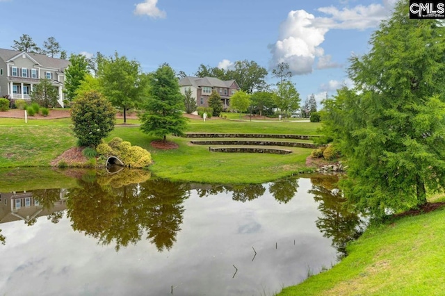 view of property's community featuring a lawn and a water view