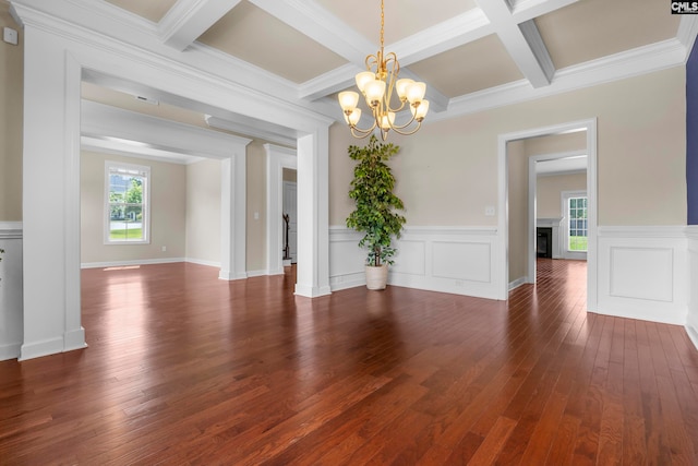 unfurnished room featuring crown molding, dark wood-type flooring, and a notable chandelier