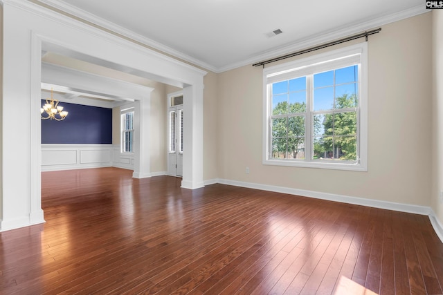 unfurnished living room with dark hardwood / wood-style flooring, crown molding, and a notable chandelier