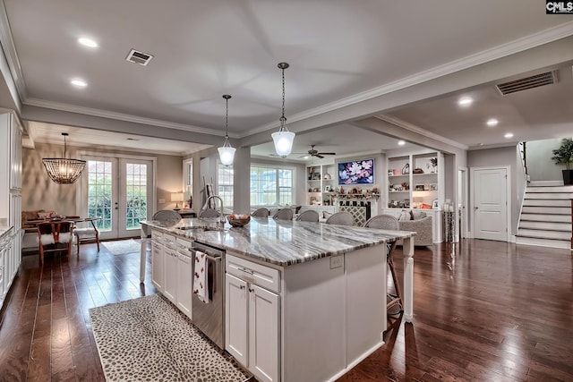 kitchen featuring dark hardwood / wood-style flooring, pendant lighting, a spacious island, and sink