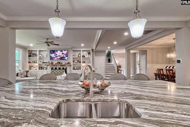 kitchen featuring decorative light fixtures, ornamental molding, and sink