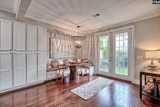 entryway featuring breakfast area, ornamental molding, dark wood-type flooring, and french doors