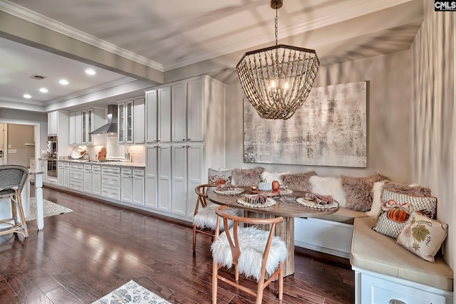 dining area featuring breakfast area, crown molding, dark wood-type flooring, and a chandelier