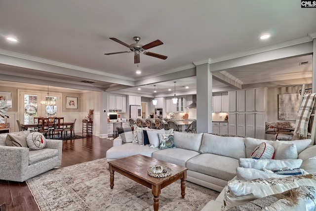 living room with ceiling fan with notable chandelier, hardwood / wood-style flooring, and crown molding