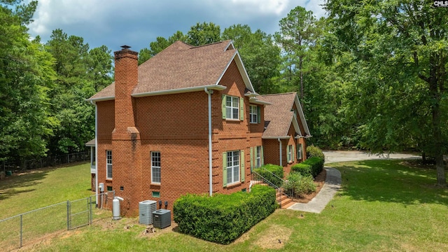 view of side of home with a lawn and cooling unit