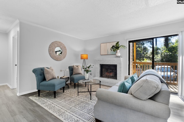 living room with a textured ceiling, light hardwood / wood-style floors, crown molding, and a fireplace