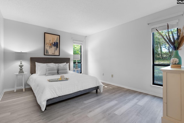 bedroom with light hardwood / wood-style floors and a textured ceiling