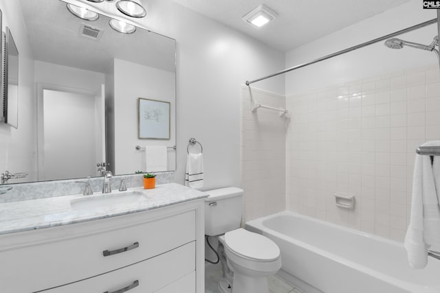 full bathroom featuring vanity, tiled shower / bath combo, a textured ceiling, and toilet