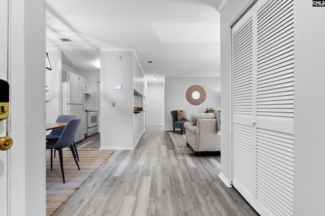 hallway featuring light hardwood / wood-style flooring and ornamental molding