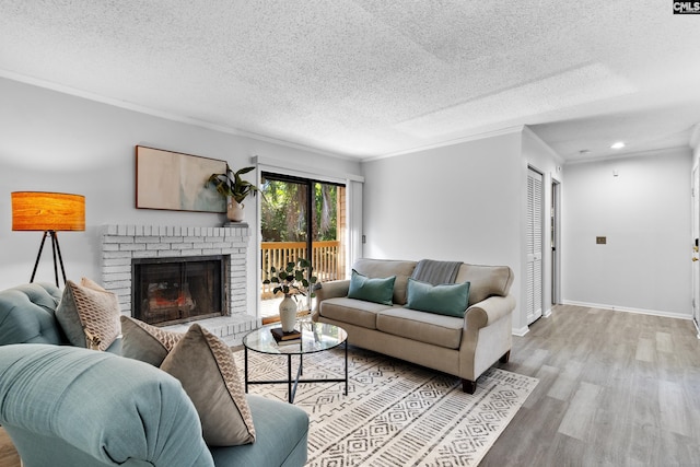 living room with ornamental molding, light wood-type flooring, a textured ceiling, and a brick fireplace