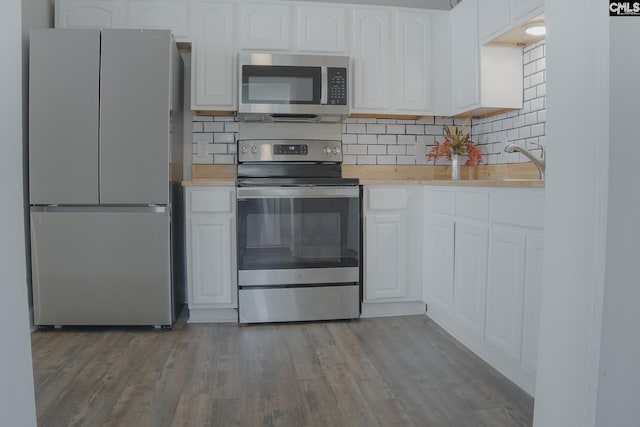 kitchen featuring appliances with stainless steel finishes, light hardwood / wood-style flooring, white cabinetry, and tasteful backsplash