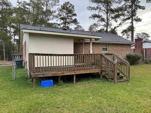 rear view of house with a lawn and a wooden deck