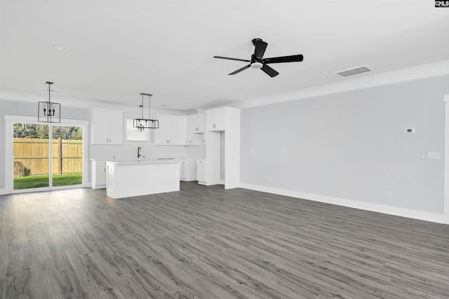 unfurnished living room featuring dark wood-type flooring, ceiling fan, crown molding, and sink