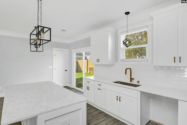 kitchen featuring white cabinetry, sink, pendant lighting, and backsplash