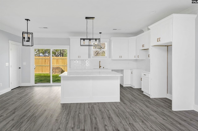 kitchen featuring sink, light hardwood / wood-style flooring, a center island, and white cabinets