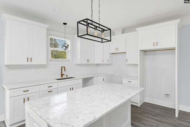 kitchen featuring white cabinetry, sink, decorative backsplash, and a kitchen island