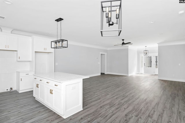 kitchen featuring white cabinetry, crown molding, a center island, hanging light fixtures, and hardwood / wood-style flooring