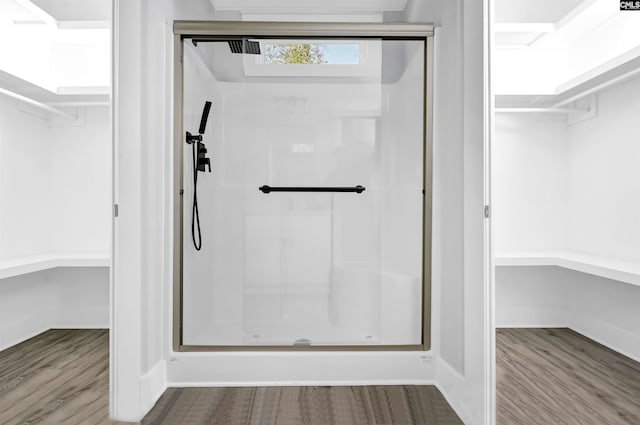 bathroom featuring hardwood / wood-style flooring and walk in shower