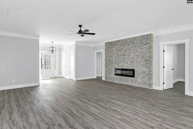 unfurnished living room featuring crown molding, a fireplace, dark hardwood / wood-style floors, and ceiling fan