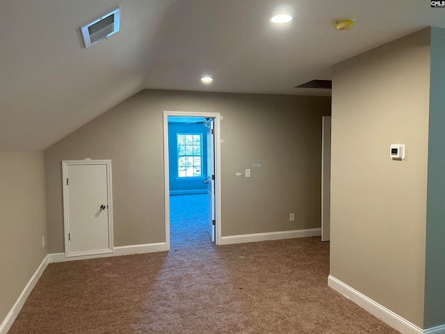 additional living space with carpet flooring and vaulted ceiling