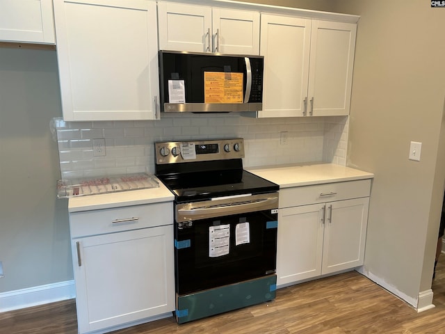 kitchen with decorative backsplash, wood-type flooring, white cabinetry, and appliances with stainless steel finishes