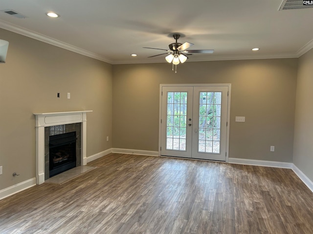 unfurnished living room featuring a tile fireplace, french doors, crown molding, ceiling fan, and dark hardwood / wood-style floors