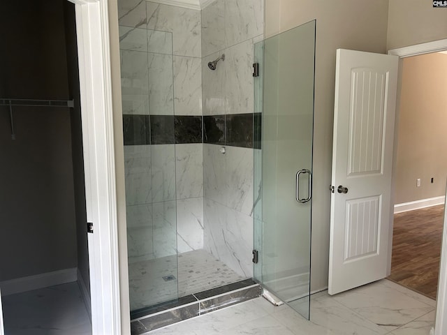 bathroom with a shower with shower door and wood-type flooring