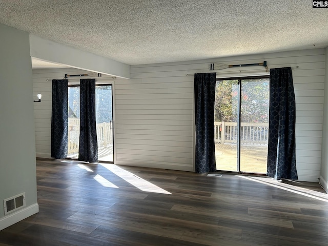 spare room with wood walls and dark hardwood / wood-style floors