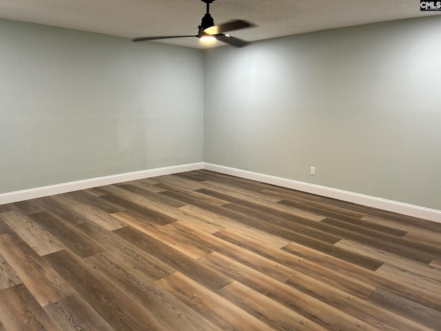 empty room featuring a textured ceiling, ceiling fan, and dark wood-type flooring