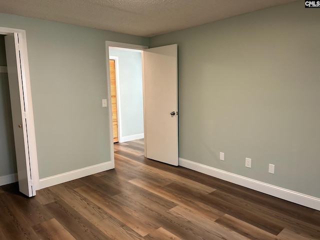 unfurnished bedroom with dark wood-type flooring and a textured ceiling