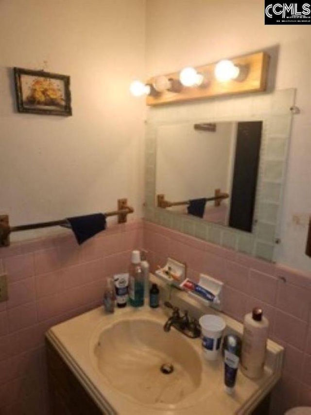 bathroom featuring vanity and tile walls