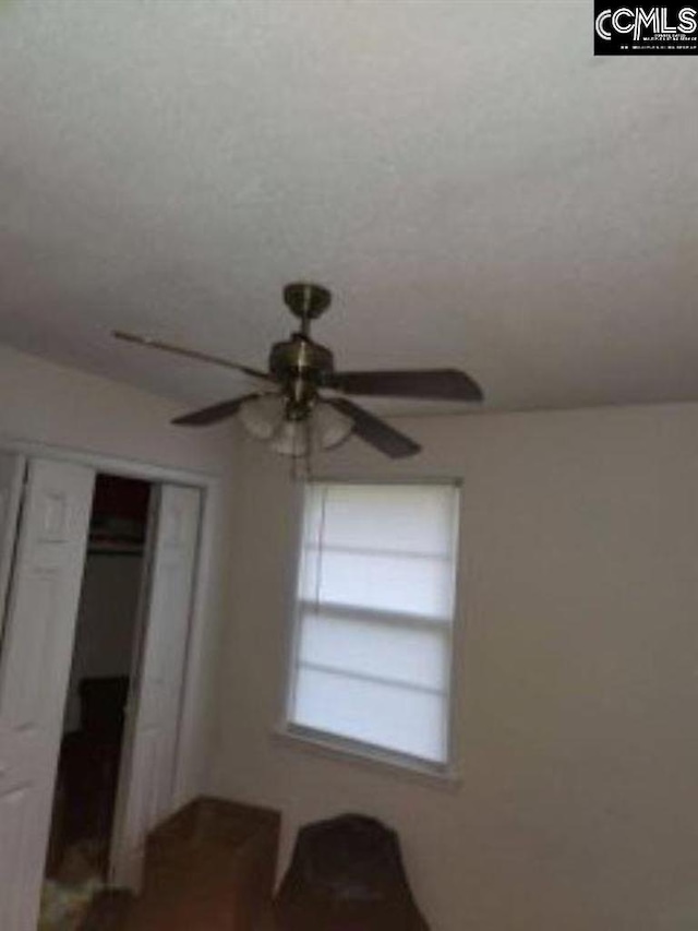 unfurnished bedroom featuring a textured ceiling, a closet, and ceiling fan