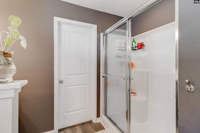 bathroom featuring hardwood / wood-style floors and a shower with shower door