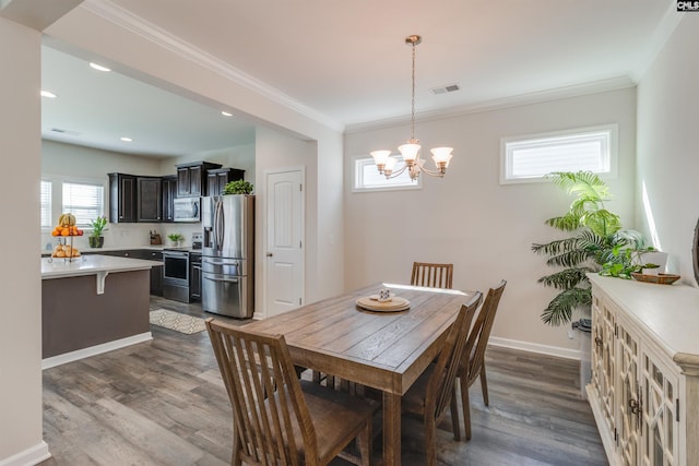 dining area with crown molding, dark wood-type flooring, and a chandelier