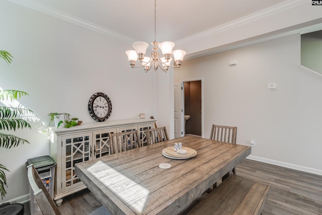 dining space with dark hardwood / wood-style flooring, an inviting chandelier, and ornamental molding